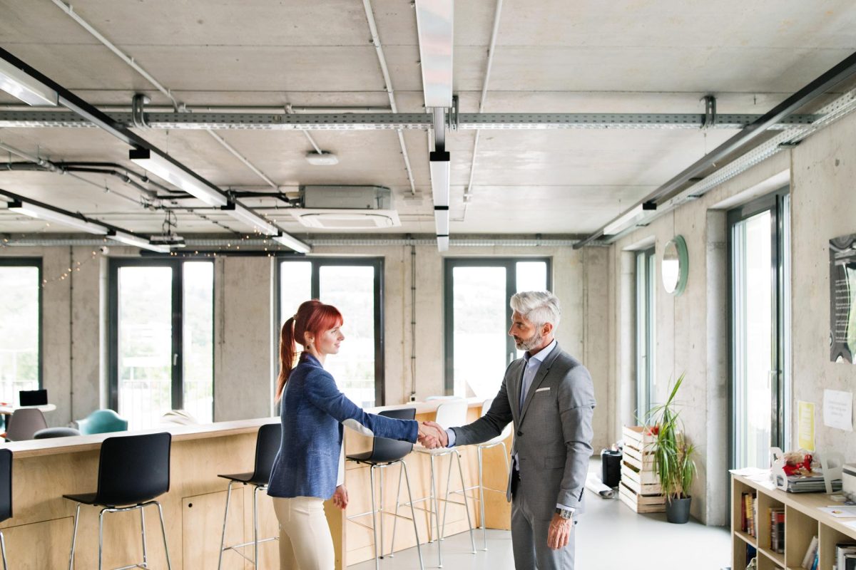 two-business-people-in-the-office-shaking-hands-PWRS4YC.jpg